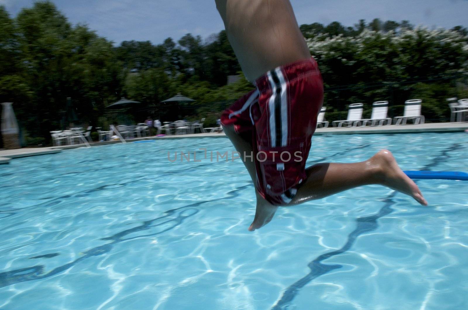 Little boy jumping into pool