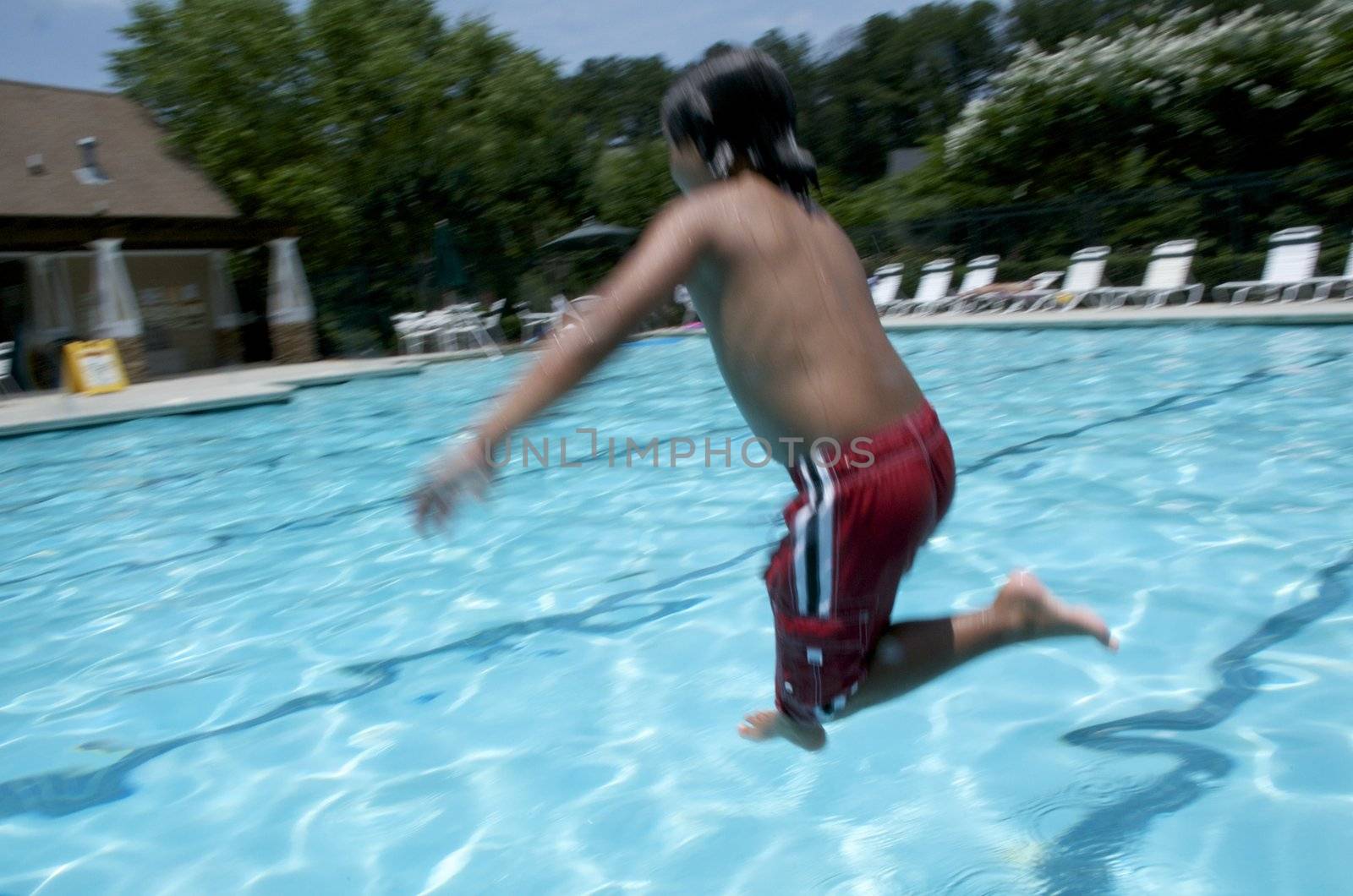 Little boy jumping into pool