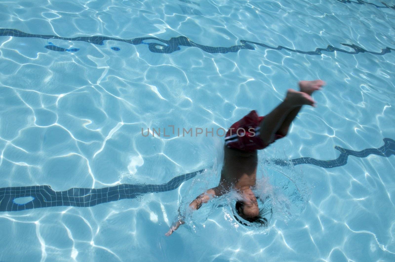 Little boy jumping into pool