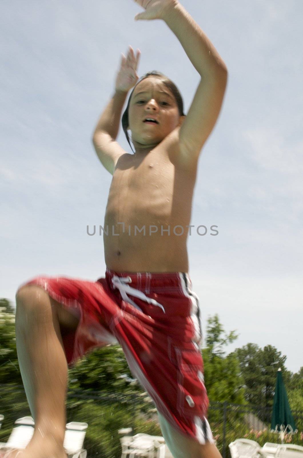 Little boy jumping into pool