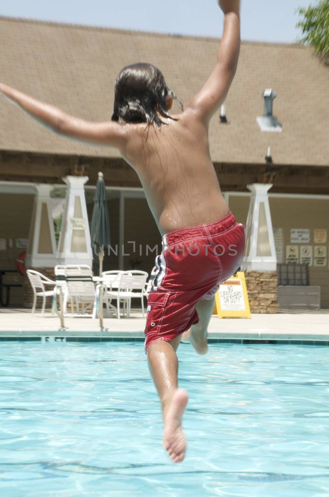 Little boy jumping into pool