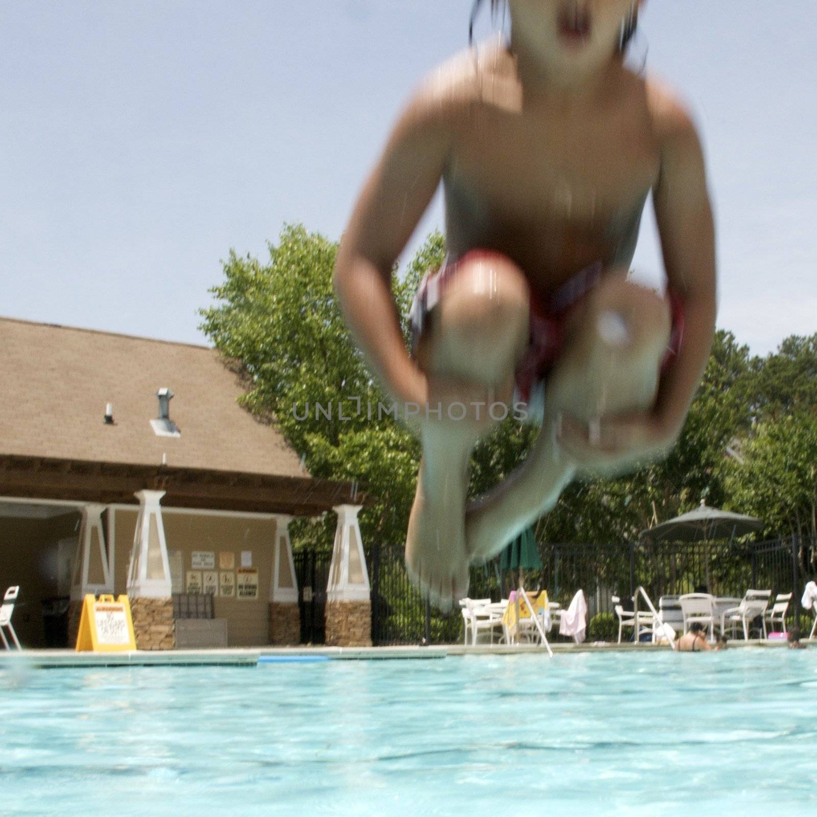 Little boy jumping into pool