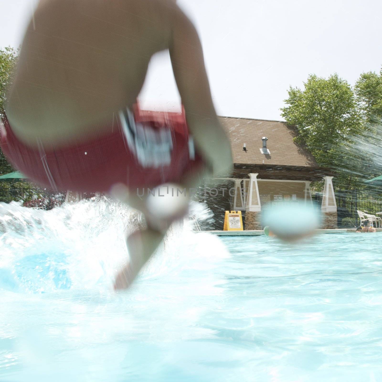 Little boy jumping into pool by jedphoto