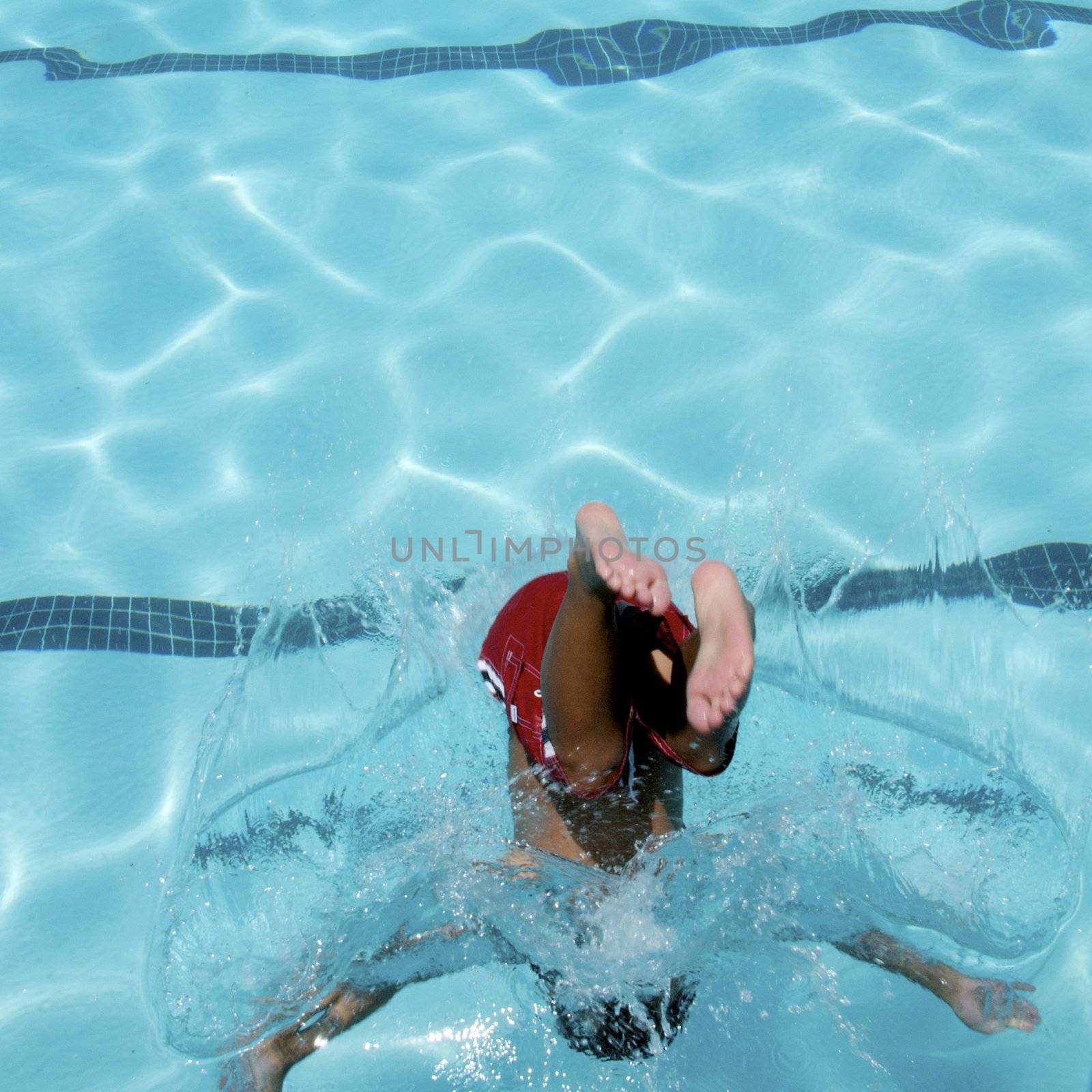 Little boy jumping into pool by jedphoto