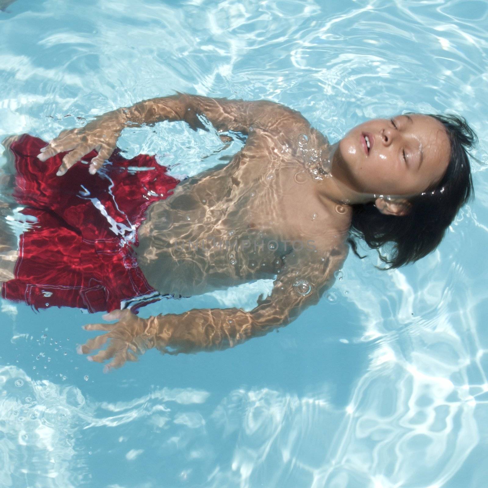 Little boy learning to swim by jedphoto