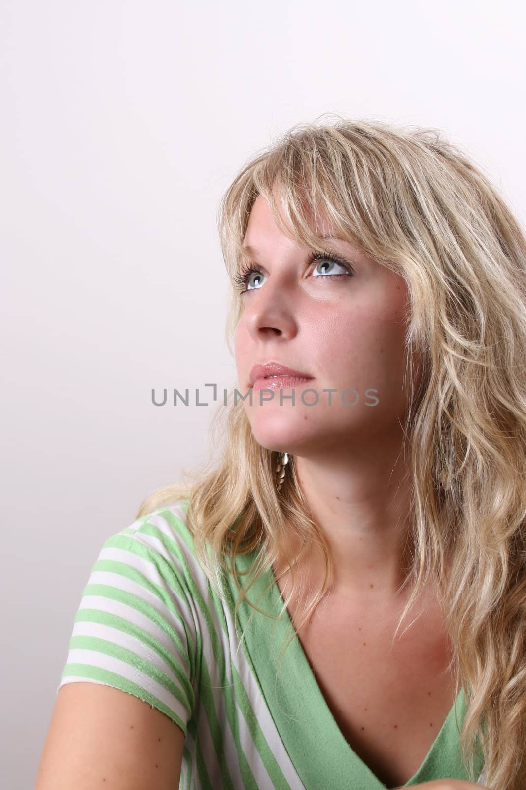 Blond Female model on a white background wearing a green top