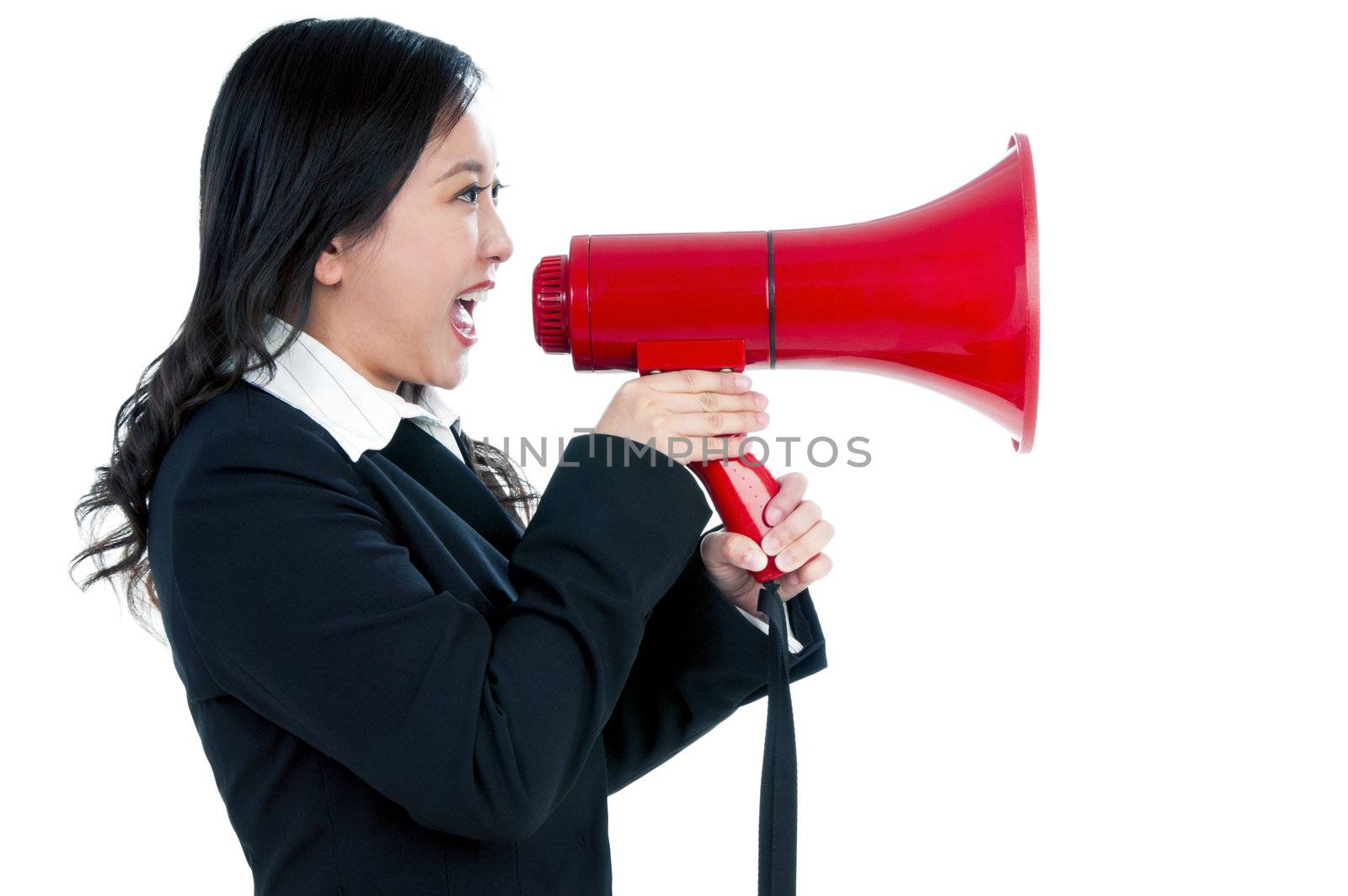 Portrait of an attractive businesswoman using a megaphone over white background.