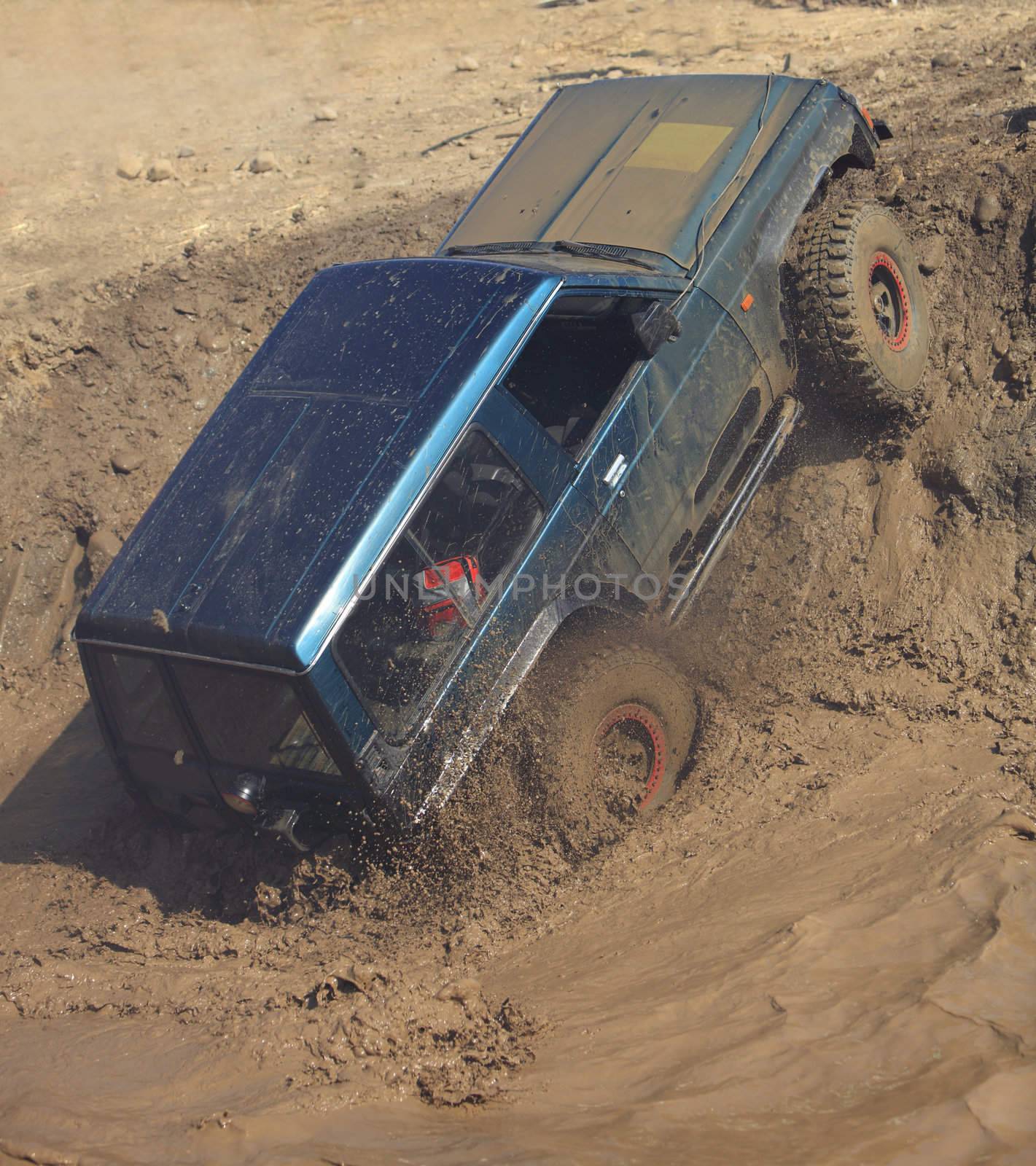 A truck during a tough off-road competition diving in a muddy pool.