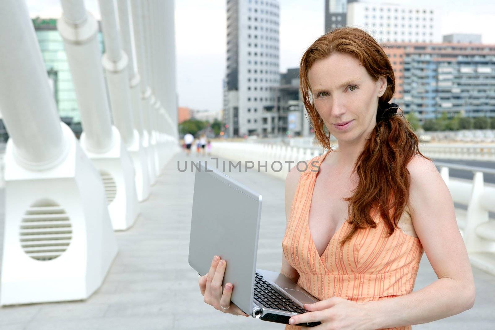 Beautiful redhead woman with laptop by lunamarina