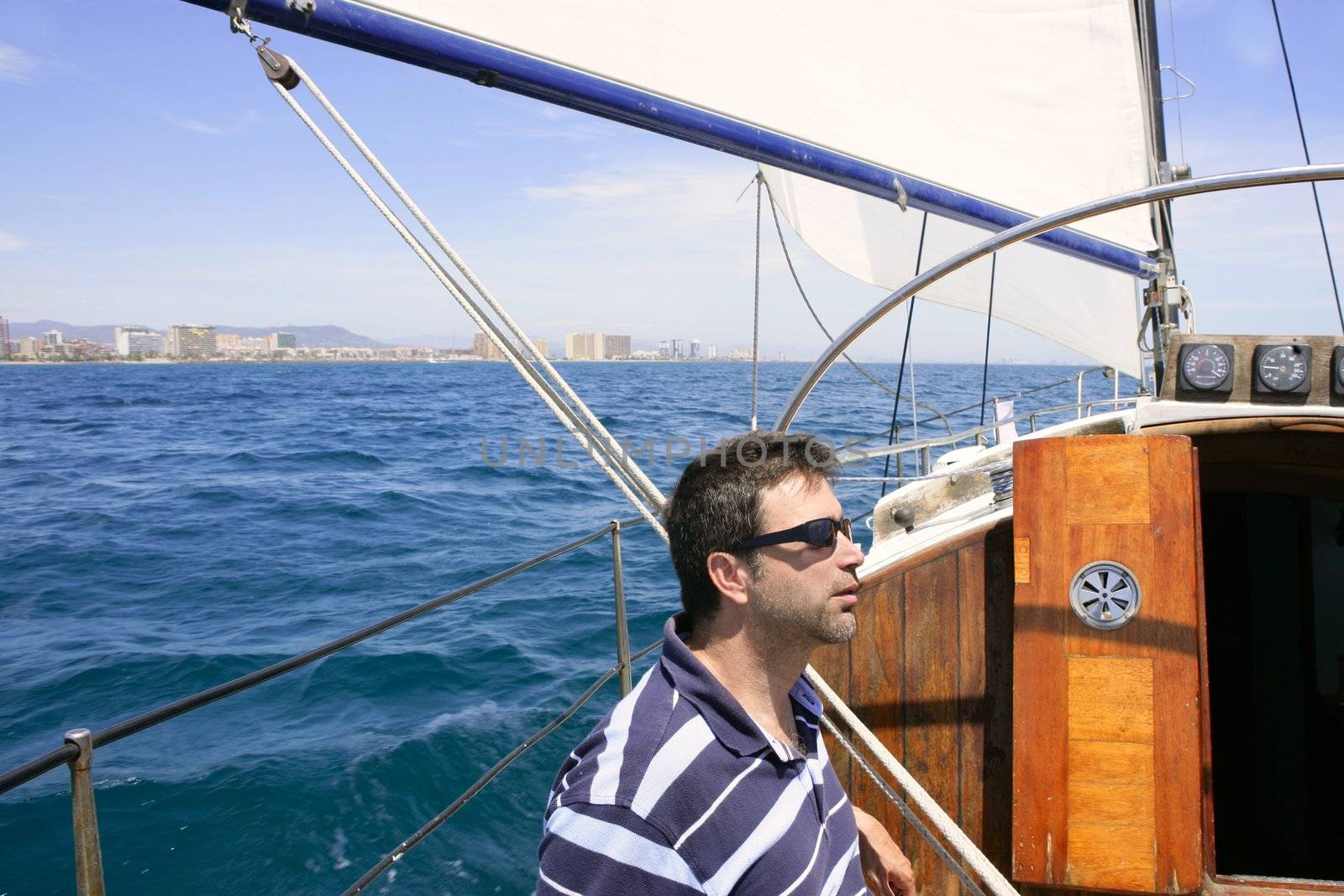 Sailor sailing blue tropical sea on sailboat in summer vacation
