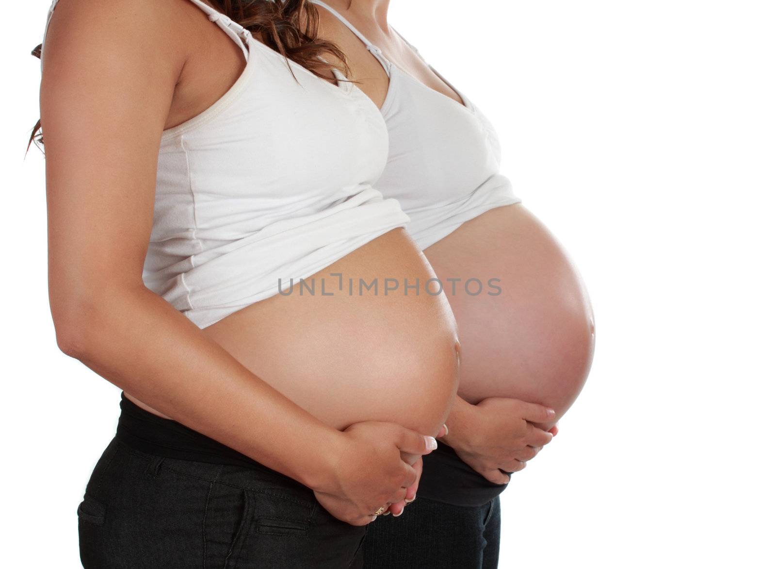 closeup on belly of two pregnant women 