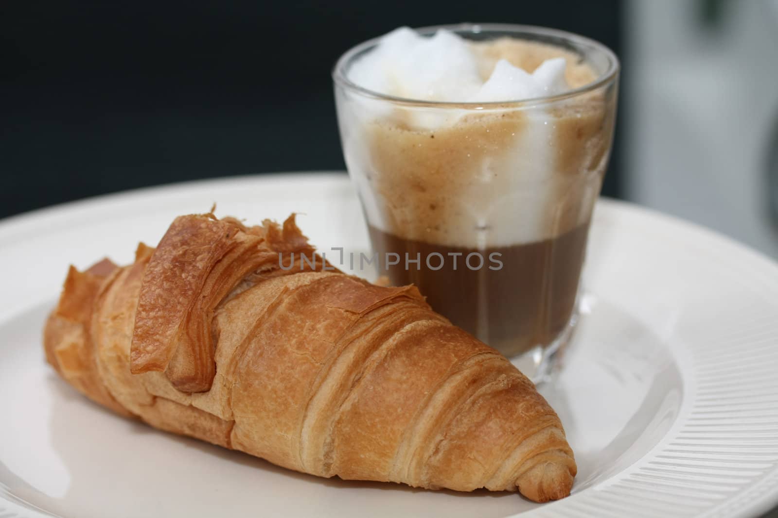 A typical French breakfast: a croissant and an espresso coffee with milk