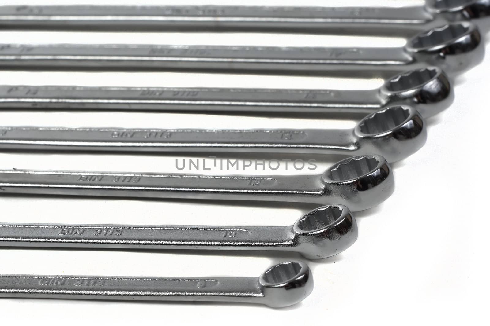 Set of steel wrenches, aligned, cropped view, emphasis and focus on the closer wrenches