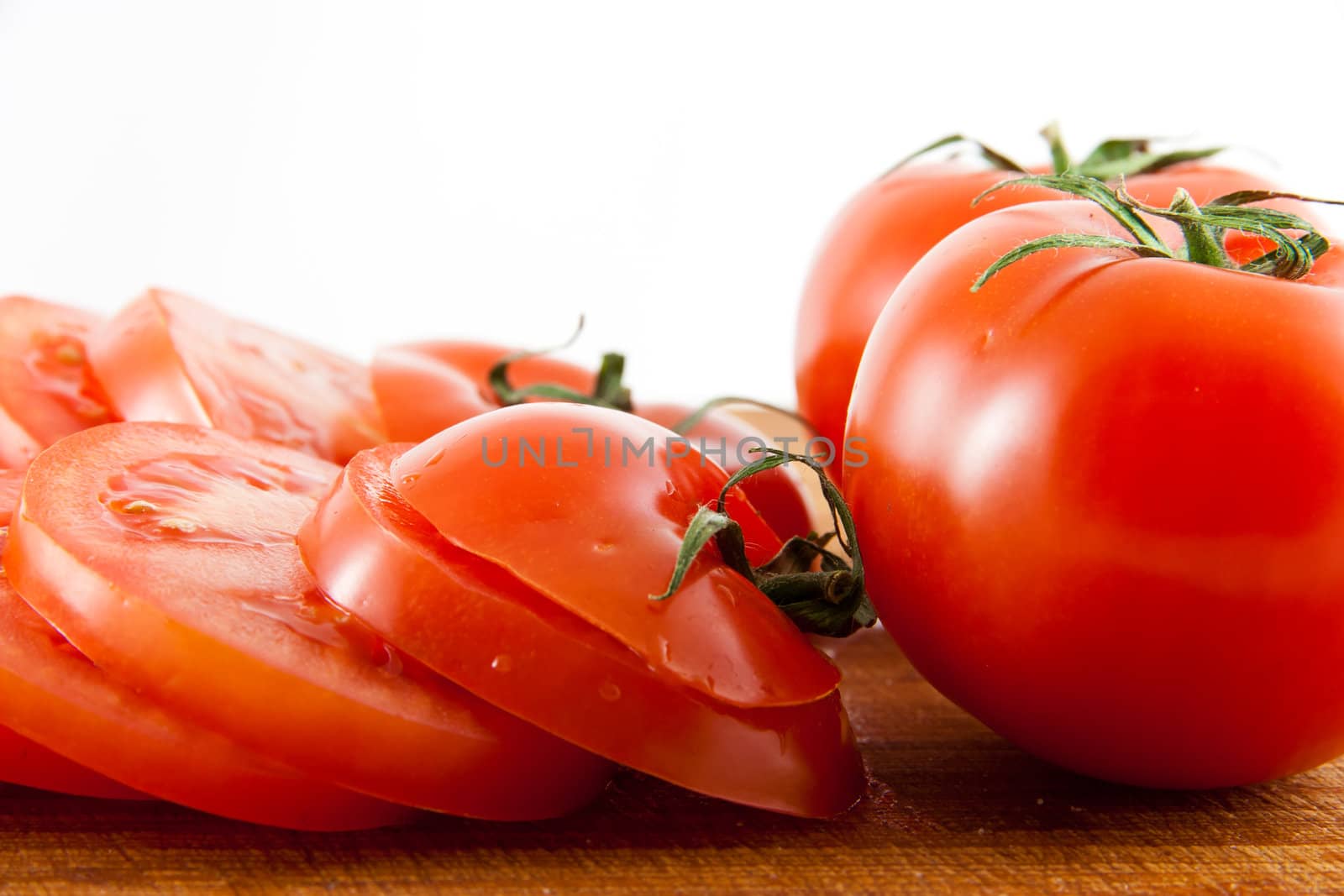 Picture of some sliced tomatoes, and two whole tomatoes
