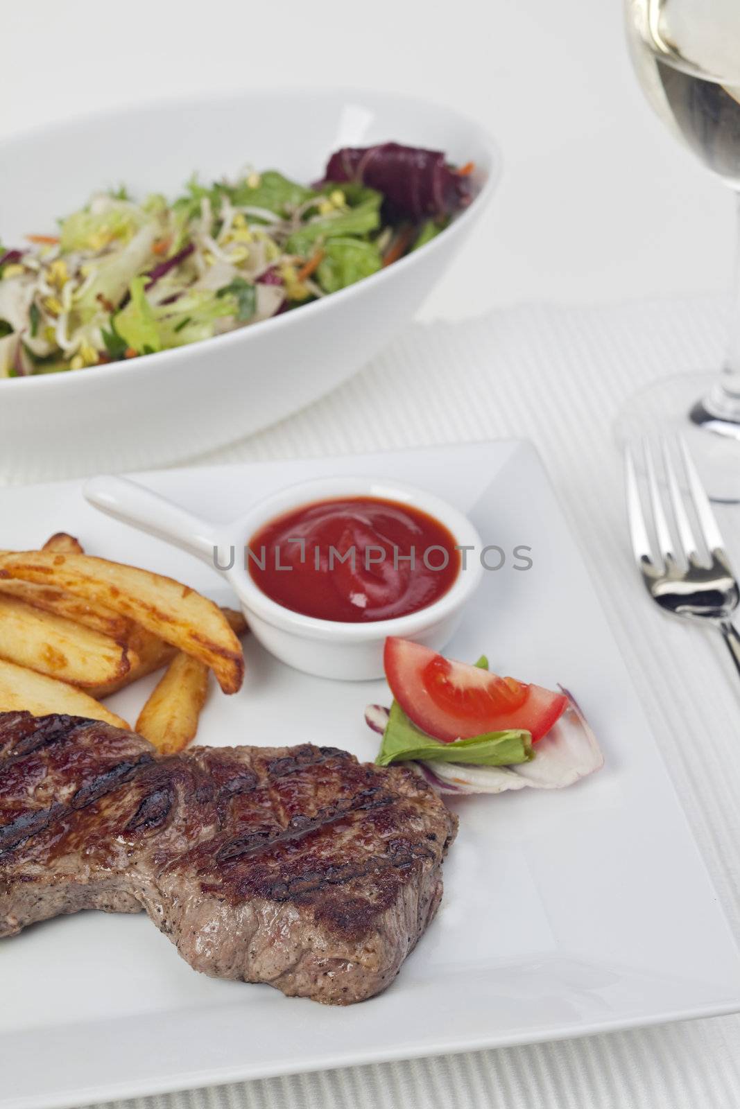 steak and french fries on a plate by bernjuer