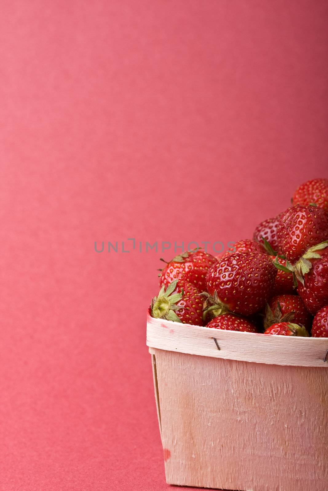 wooden quart of ripe strawberries on a solid background