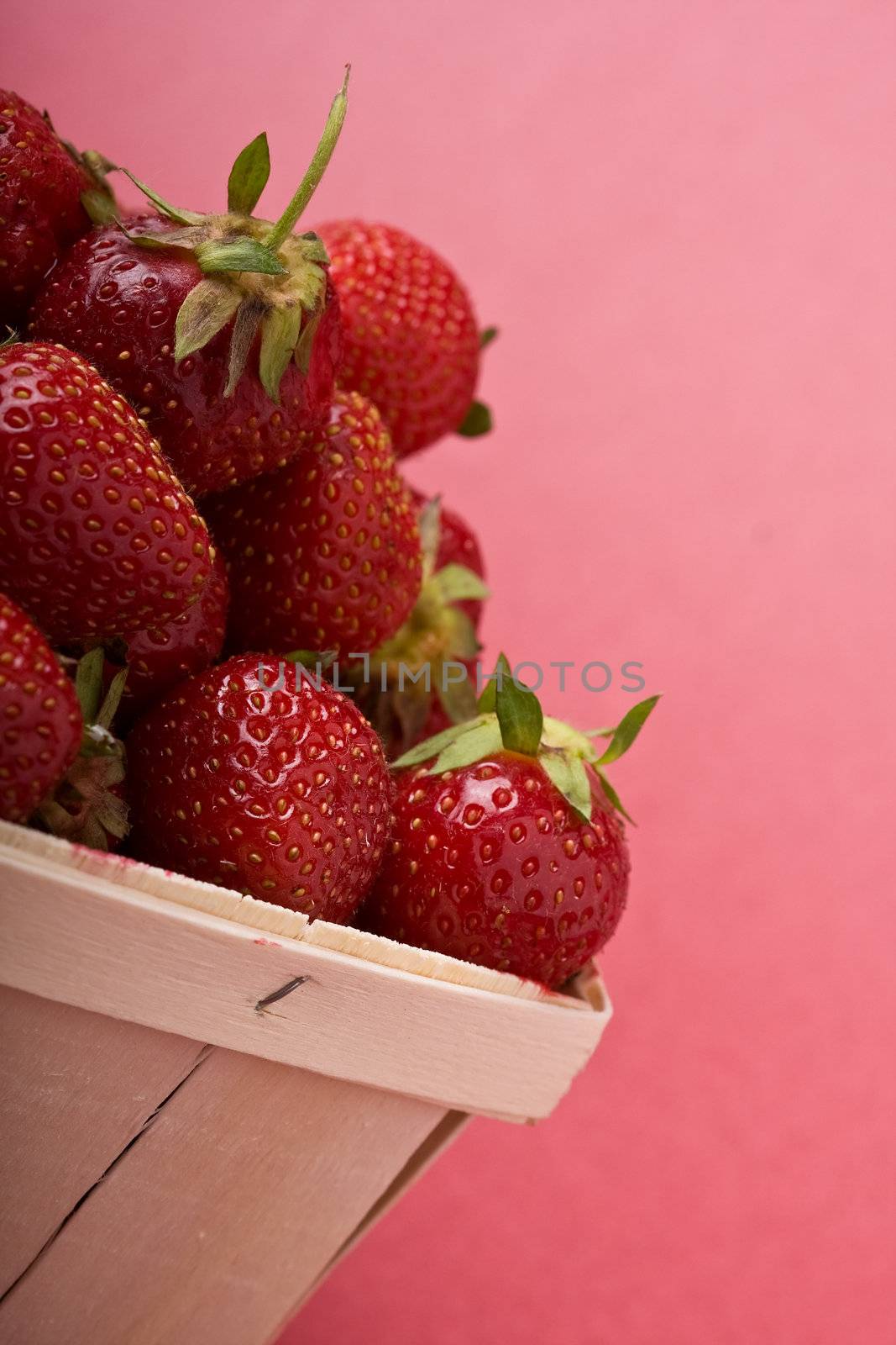 wooden quart of ripe strawberries on a solid background