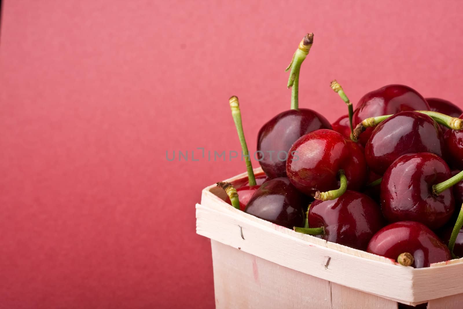quart of ripe cherries in a wood container