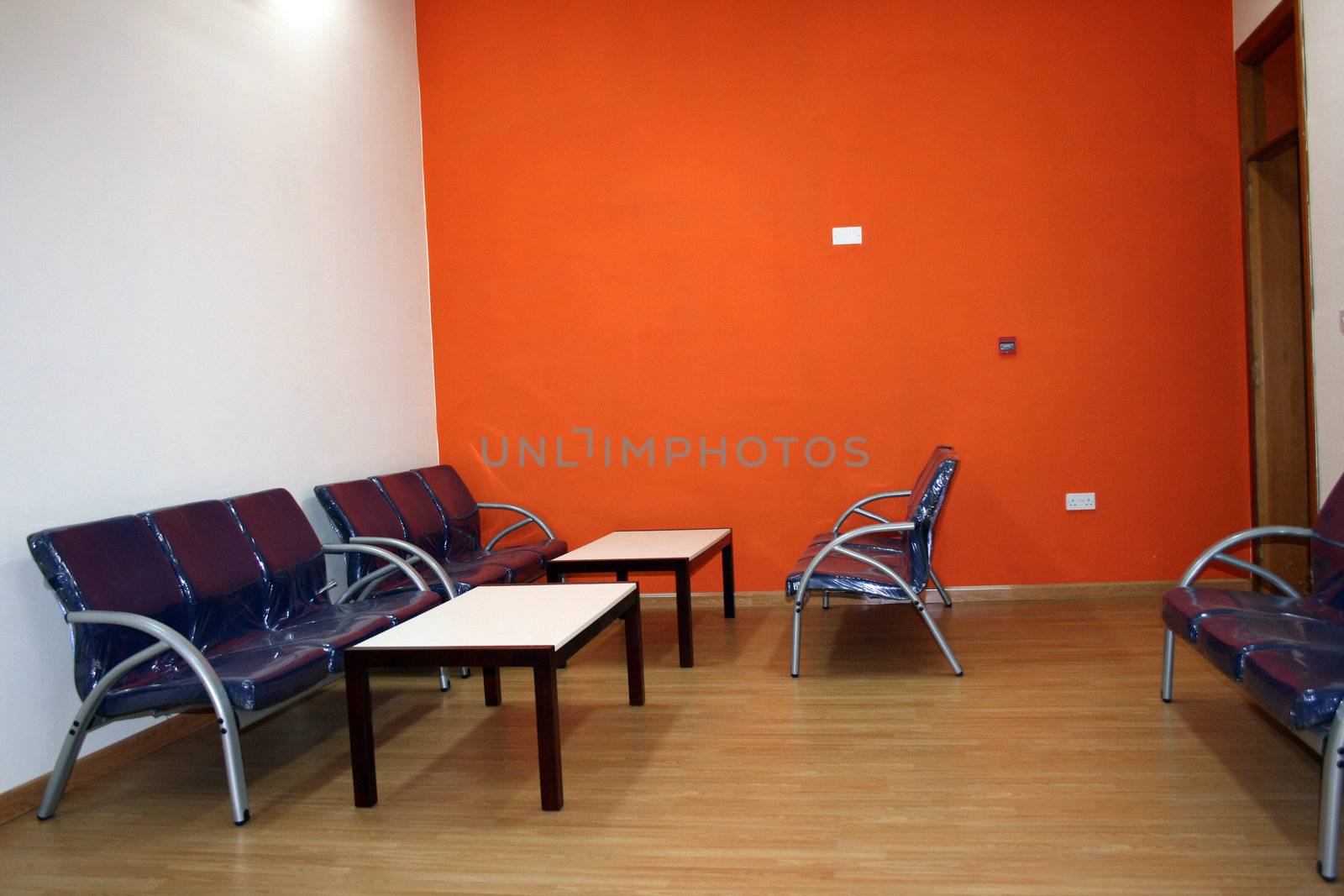 waiting area with blue chairs and bright orange walls