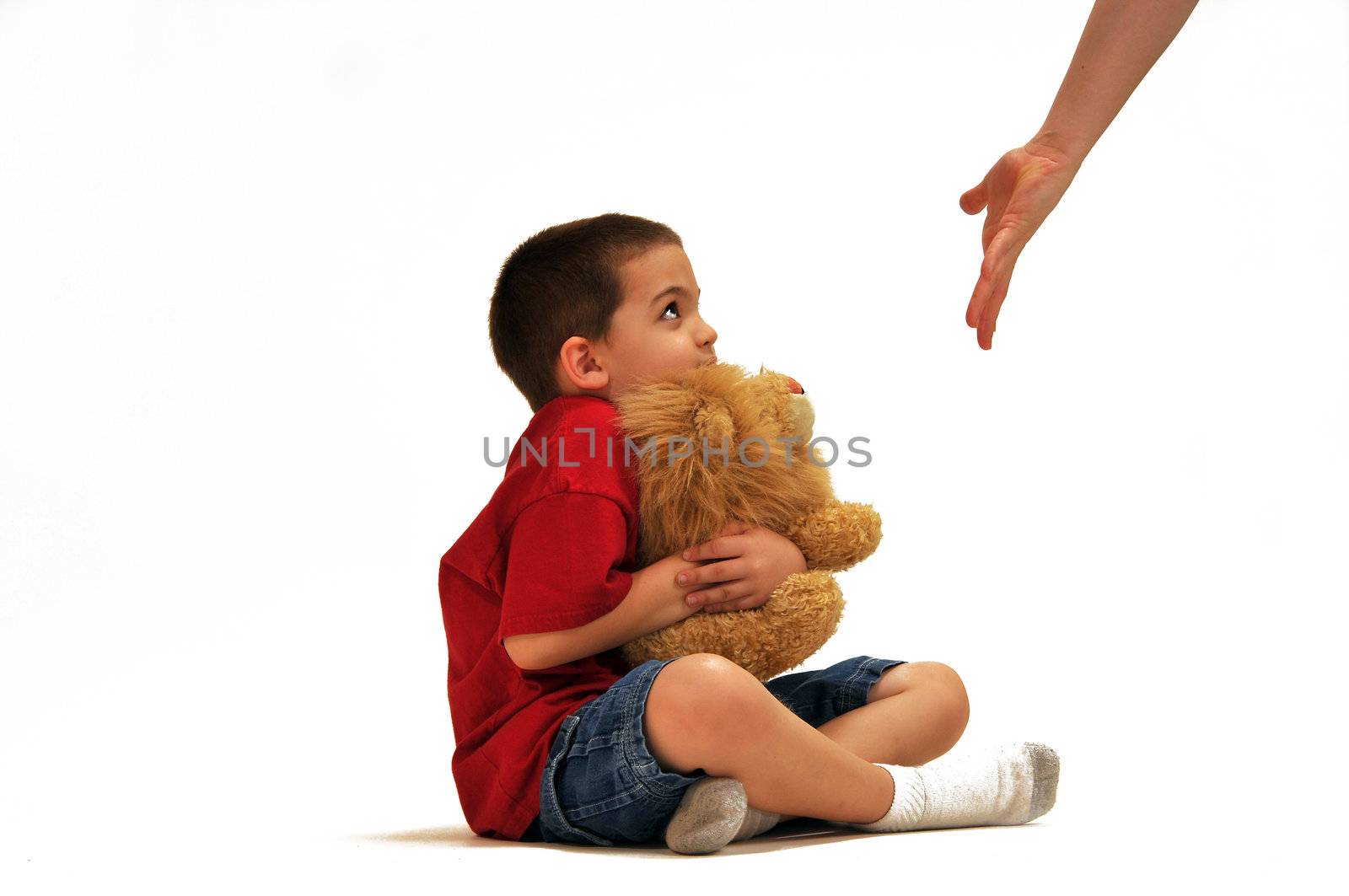 Boy holding a stuffed animal as mom's hand is outstretched demanding he give animal to her.