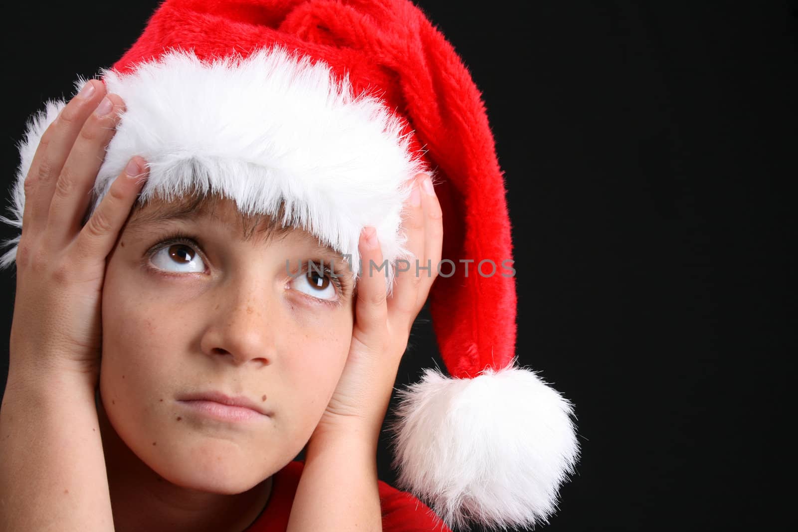 Young boy wearing a red shirt and christmas hat
