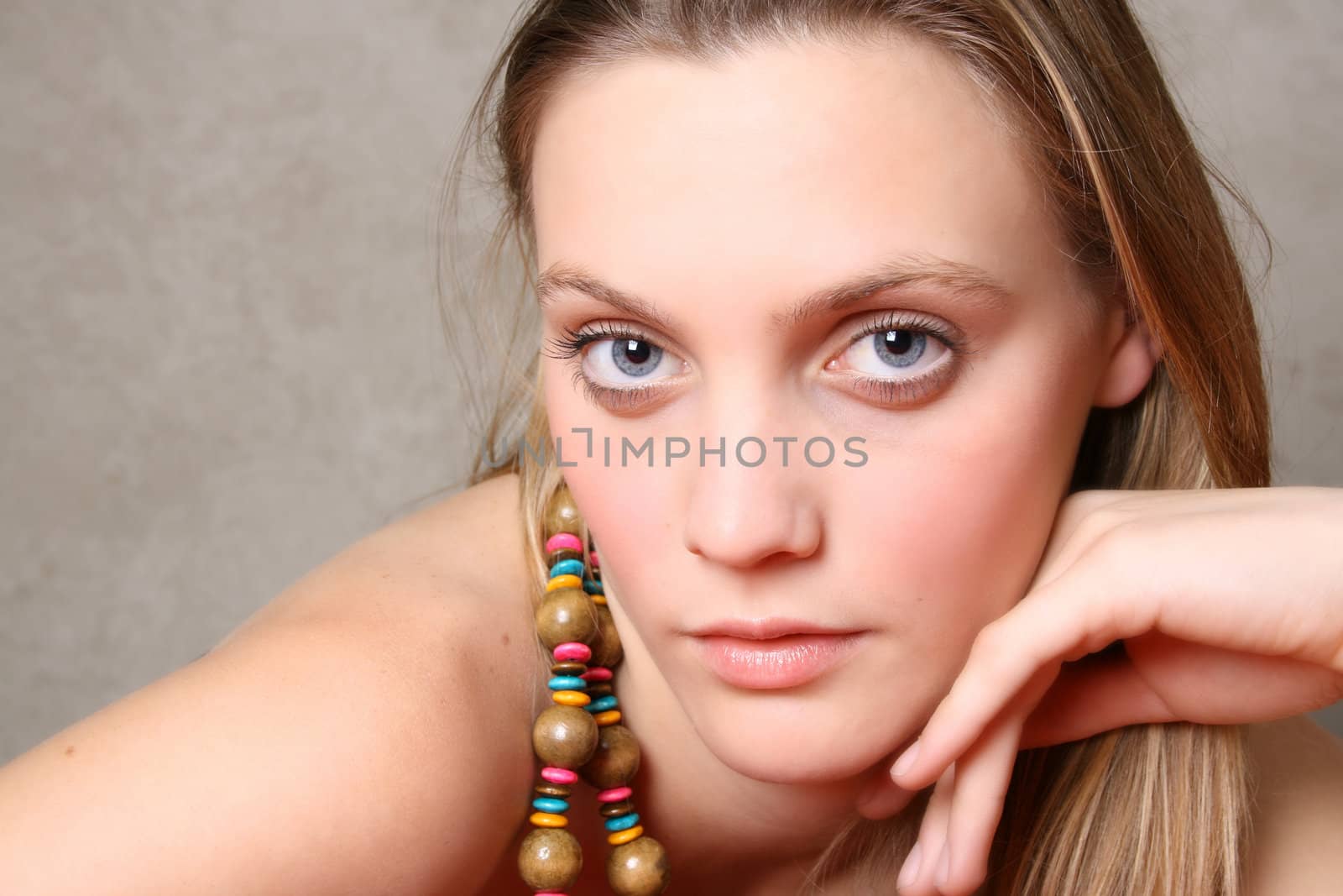 Beautiful female model with blue eyes and a string beads