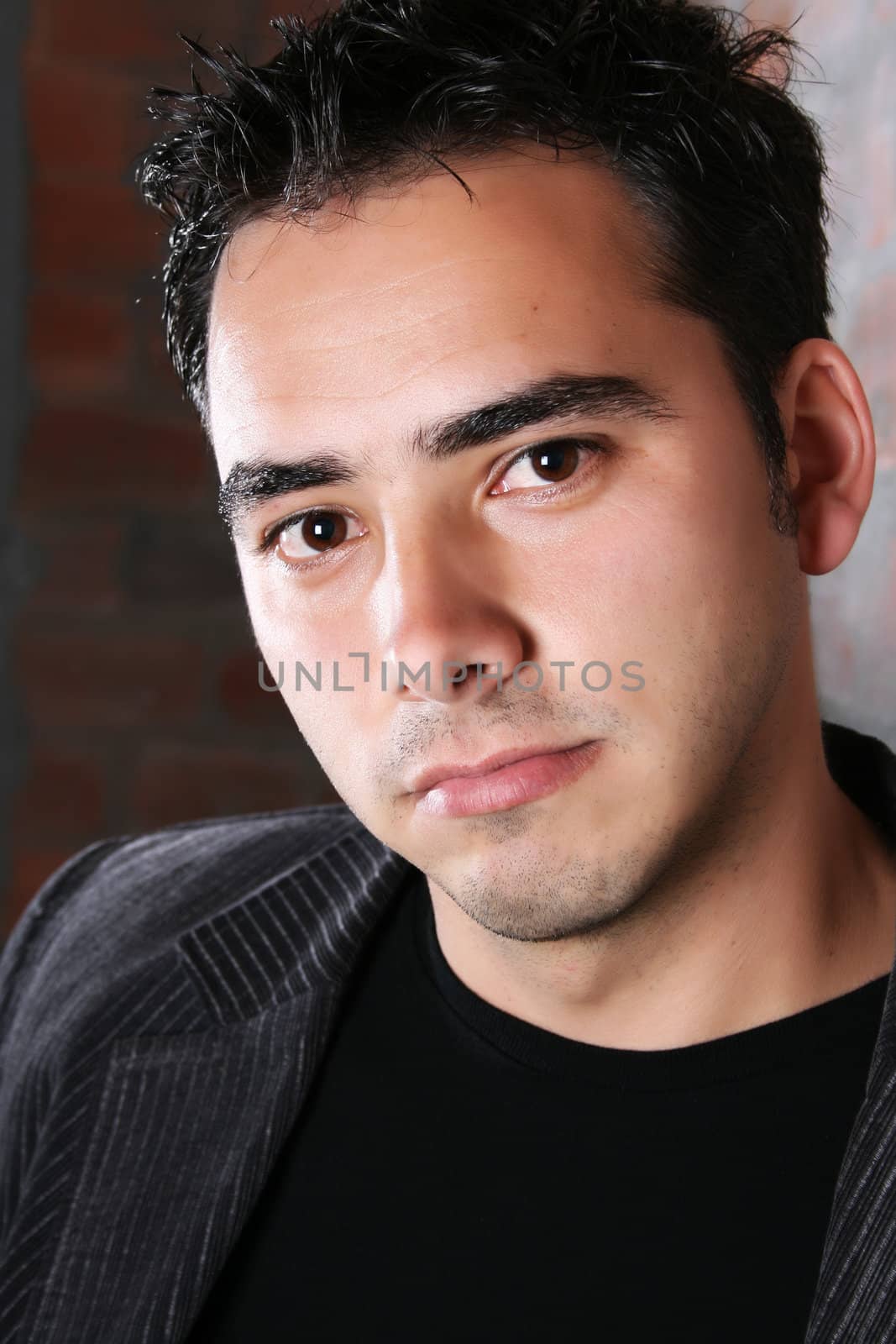 Male model against a rough brick wall background