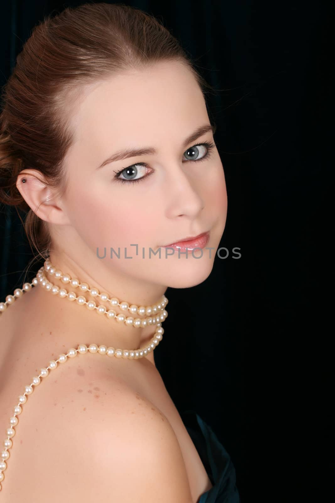 Beautiful female wrapped in fabric, wearing pearls