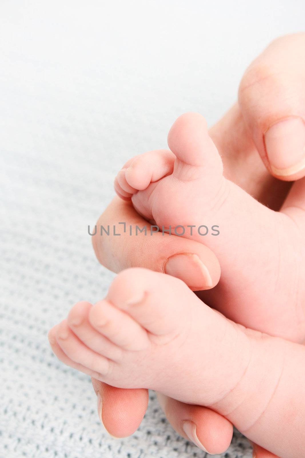 Feet of a baby in his mothers hand

