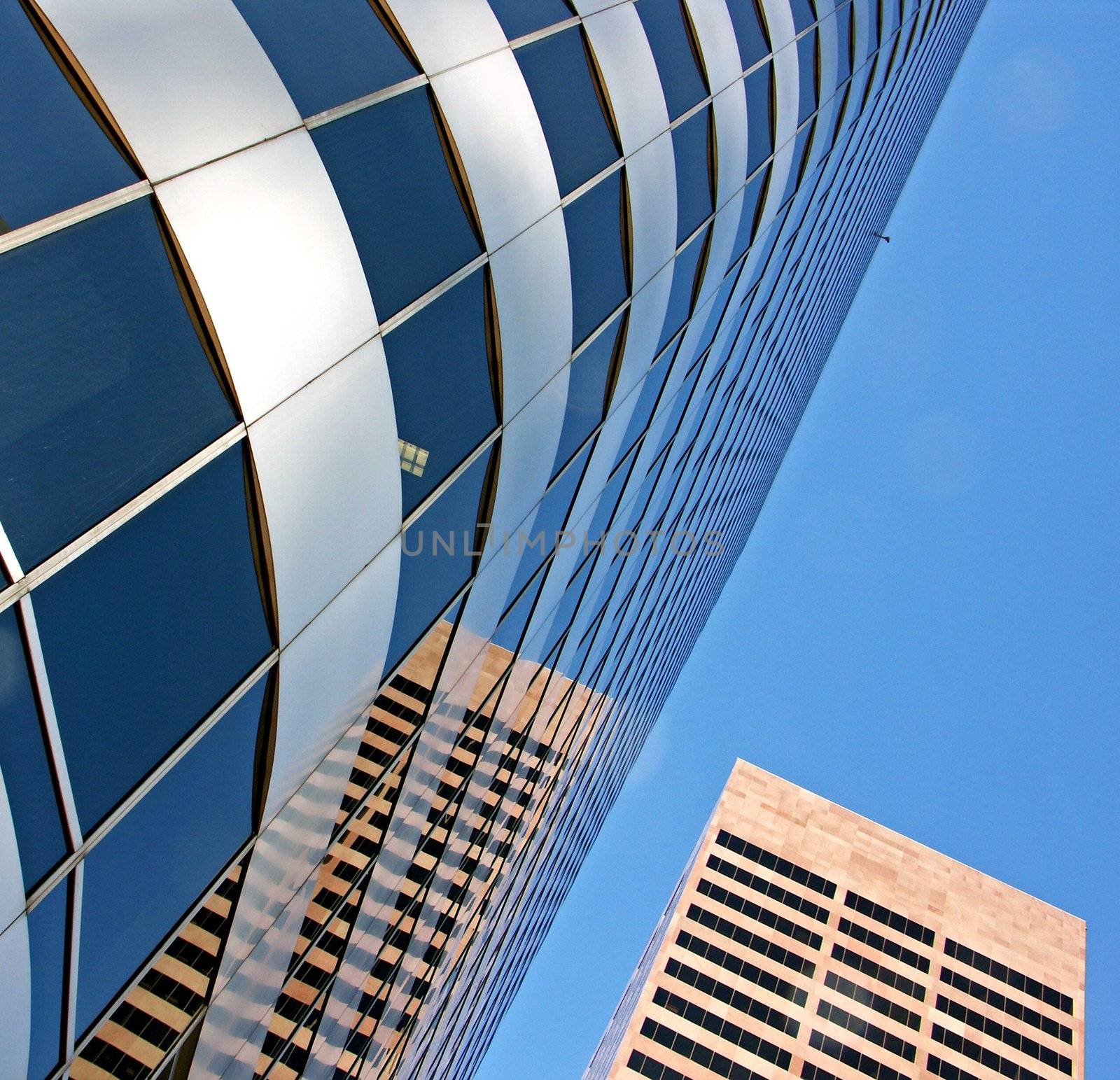 A glass and chrome building and a brick building