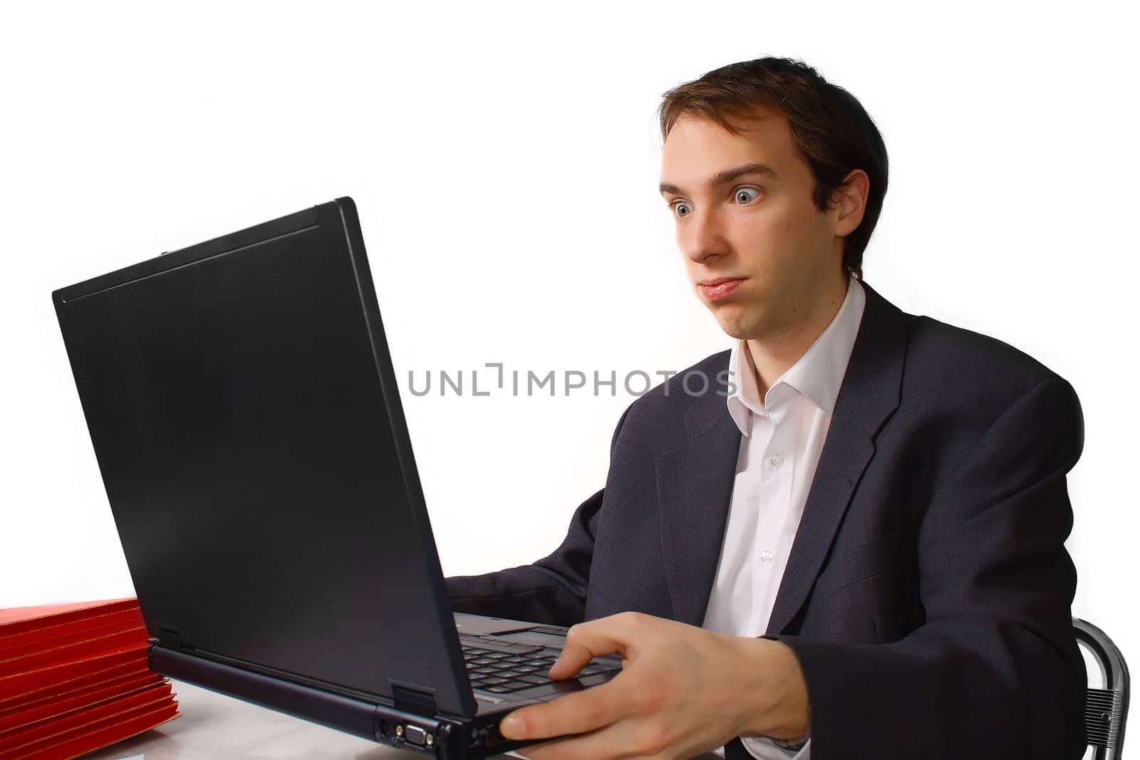 Young man holds laptop and cannot take more, isolated over white