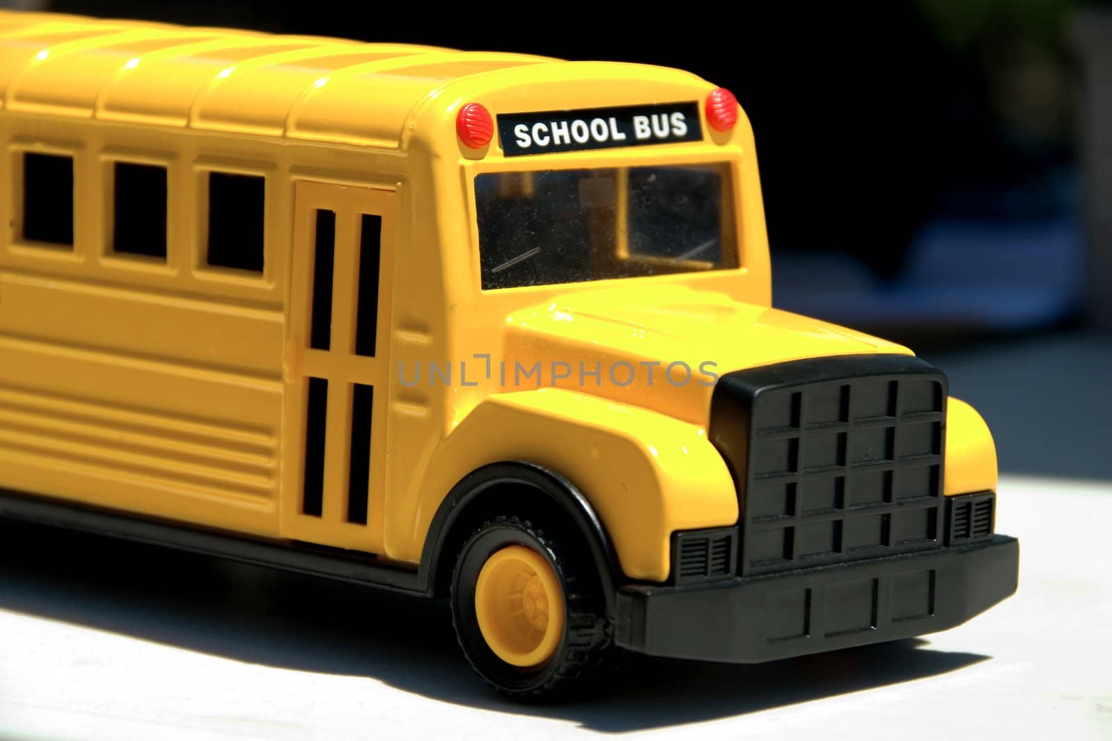 This is a picture of a toy school bus shoing the front end and entrance door.