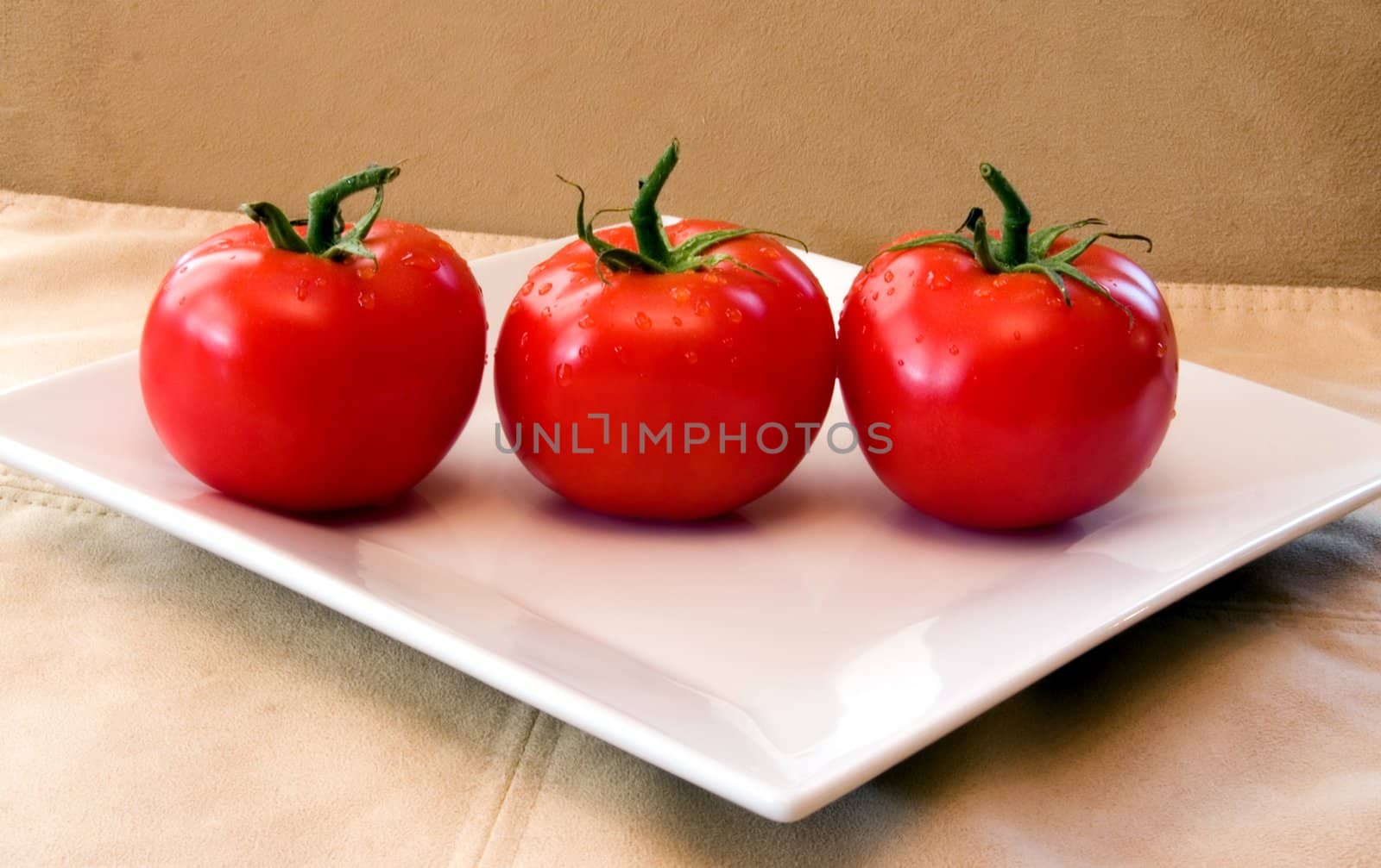 3 red vine ripened tomatoes on a white plate. by dtouch1