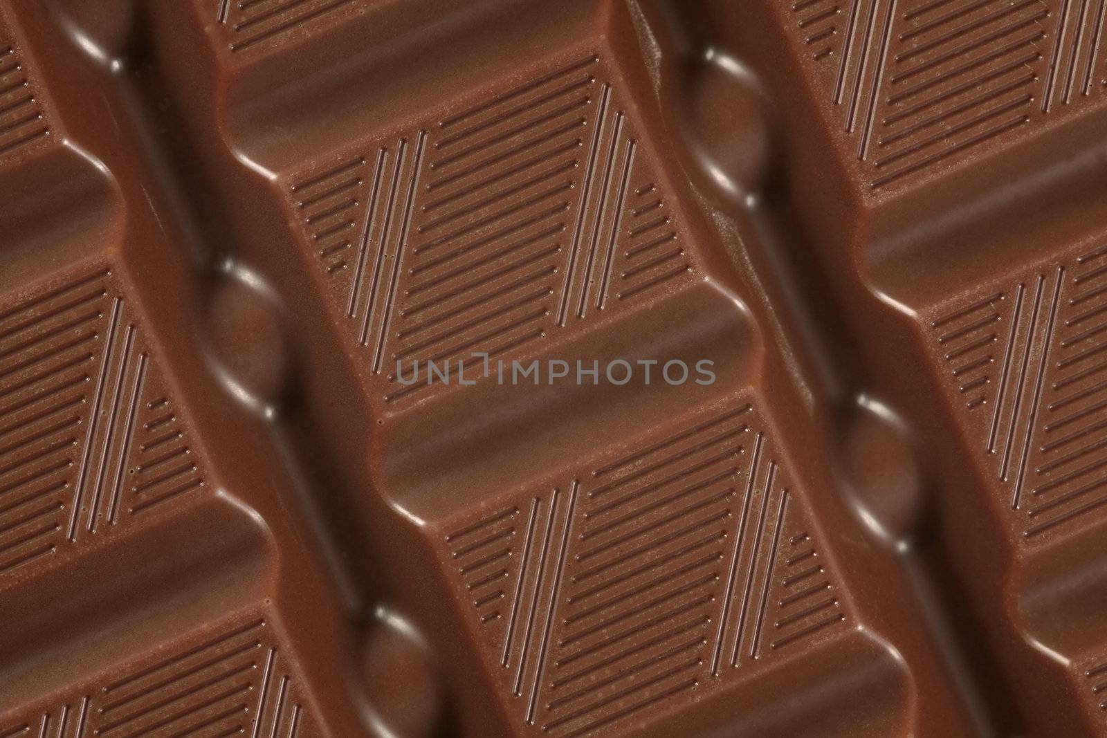 A macro photo of a large bar of milk chocolate as a background.
