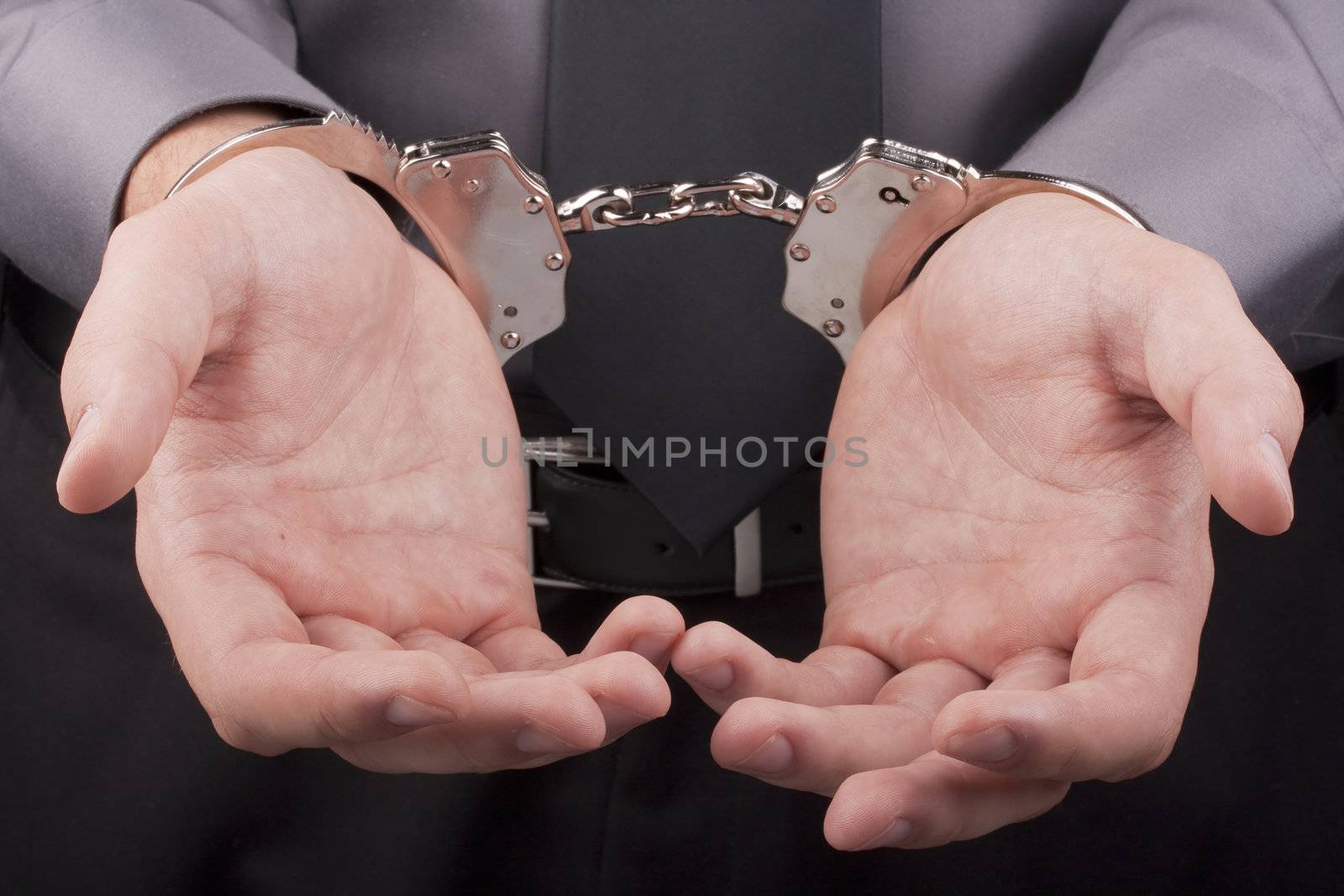 Arrest, close-up shot man's hands with handcuffs.
