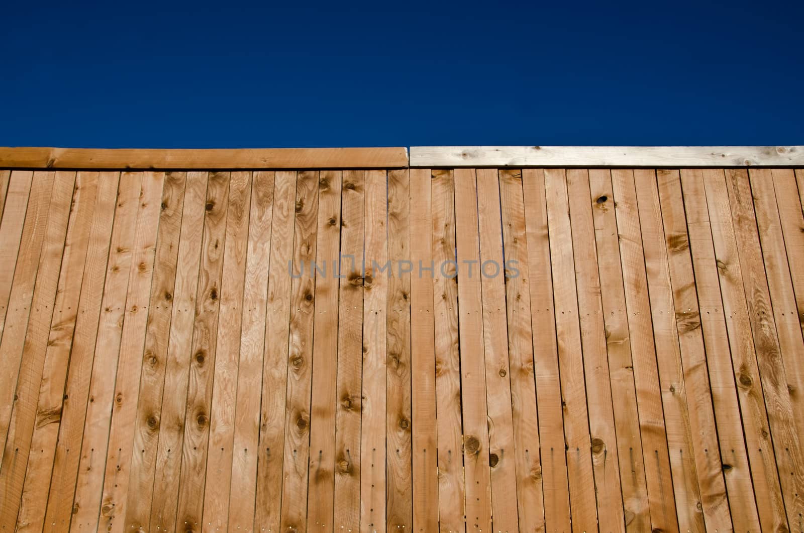 Image of a wooden fence shot from a low angle looking slightly up with blue sky