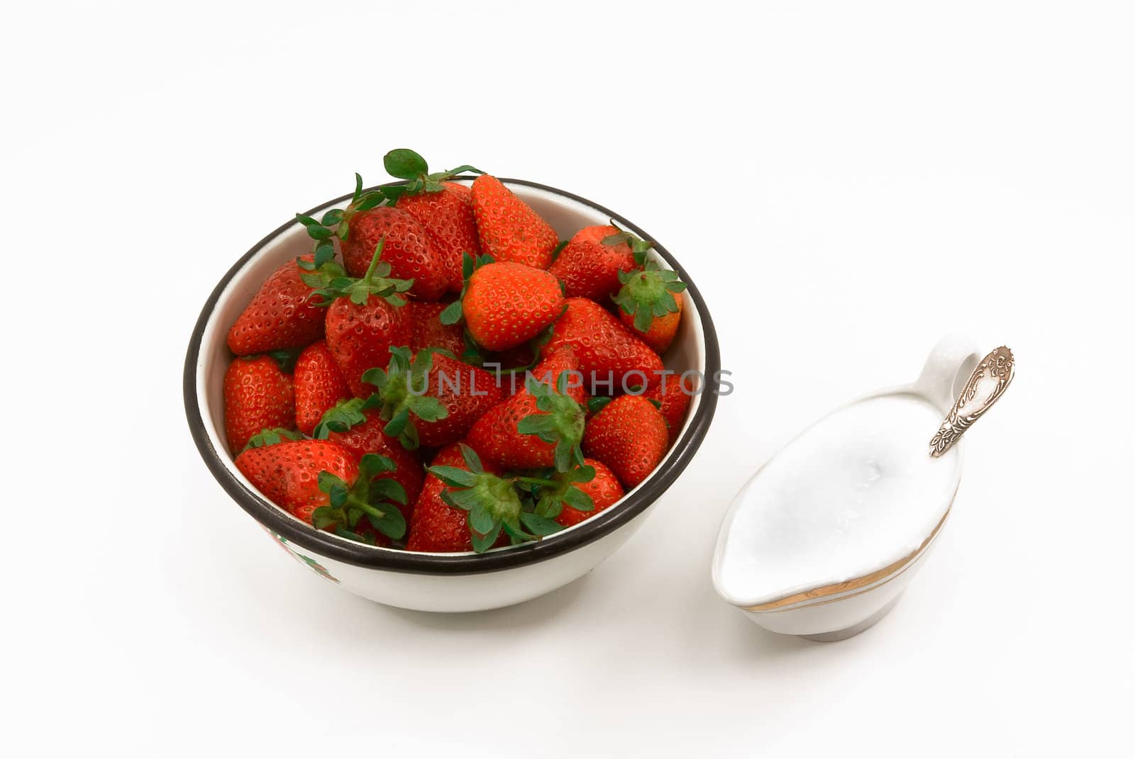 
white bowl of fresh strawberries and sour cream
  with a spoon