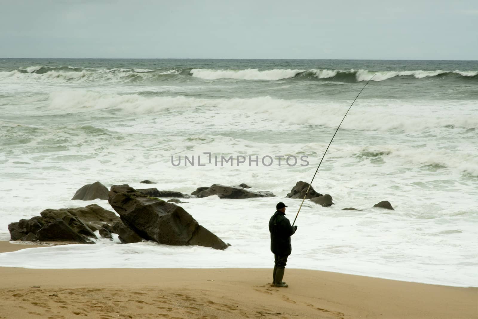 Man fising nearby stormy beacj