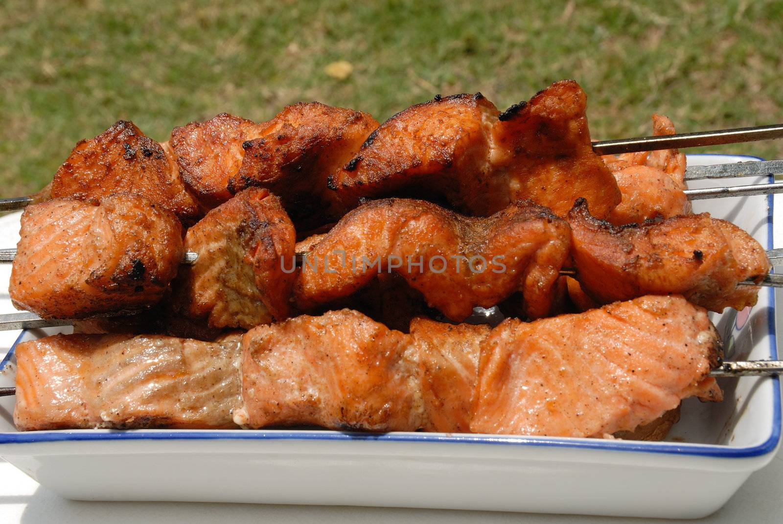 
Salmon is grilled in a white ceramic dish