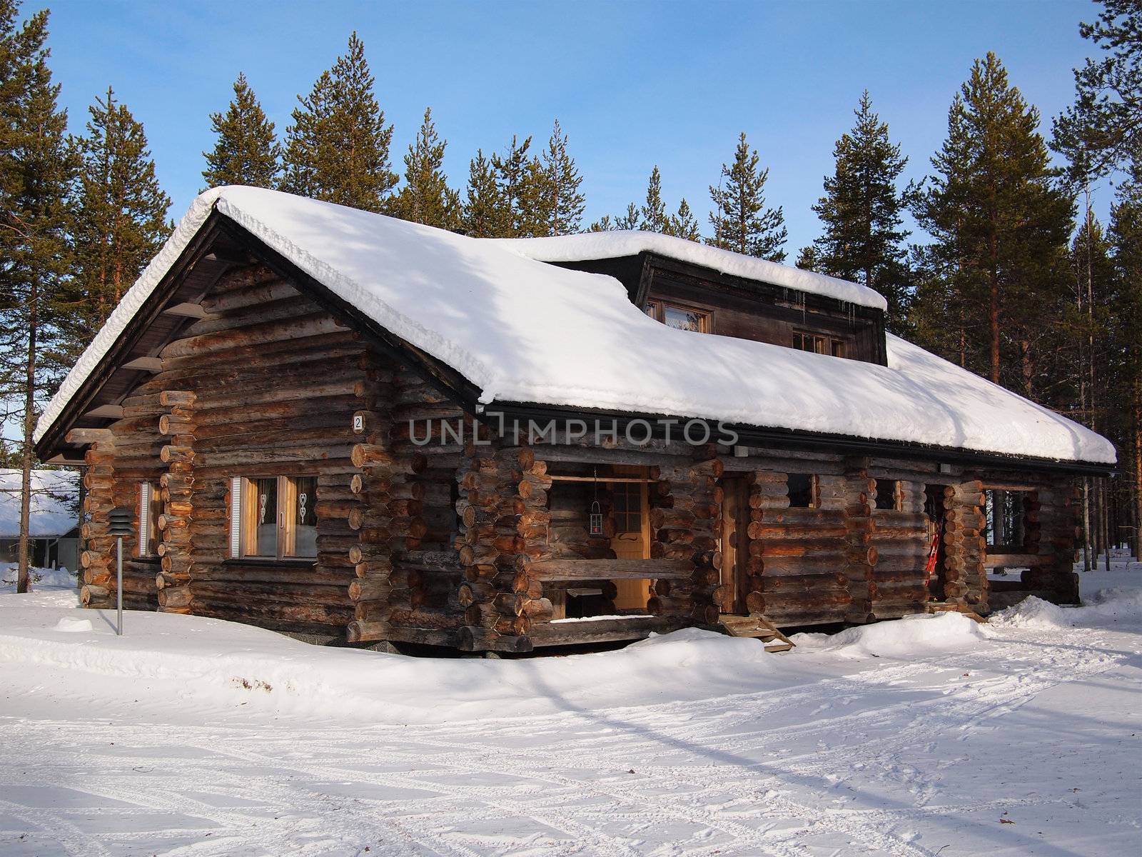 Snow-covered log cabin in a holiday resort in Yllas, Lapland, Finland.