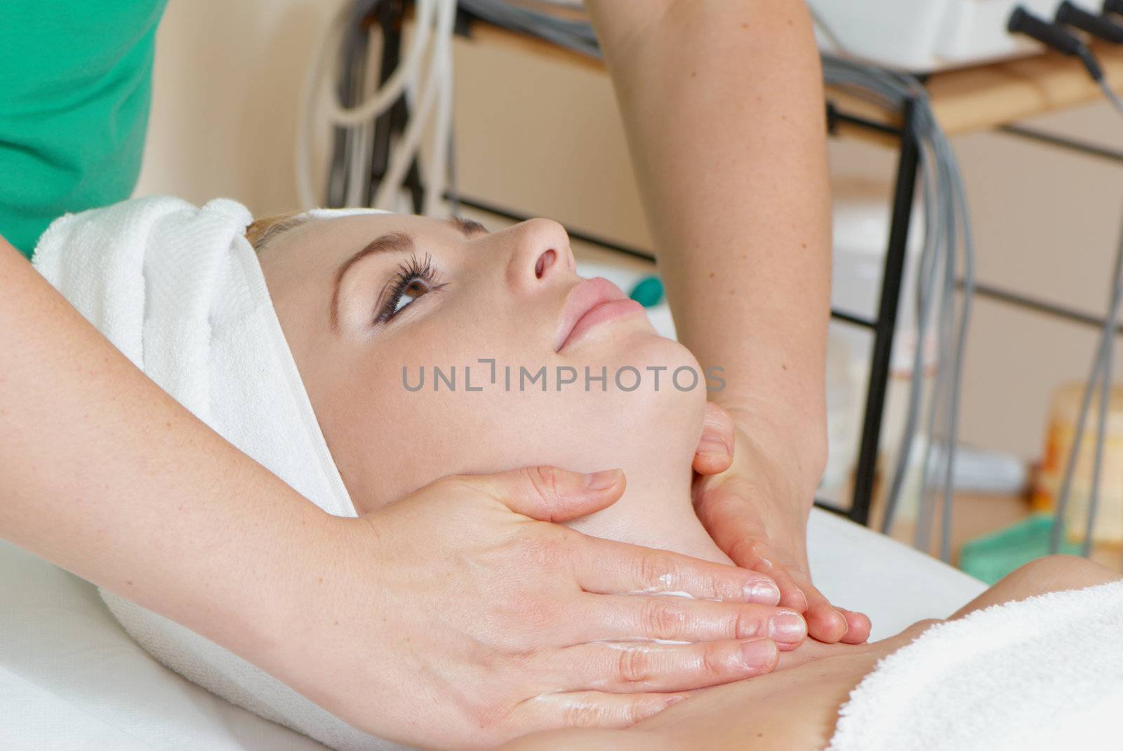 Closeup of human hands massaging a young beautiful woman's face