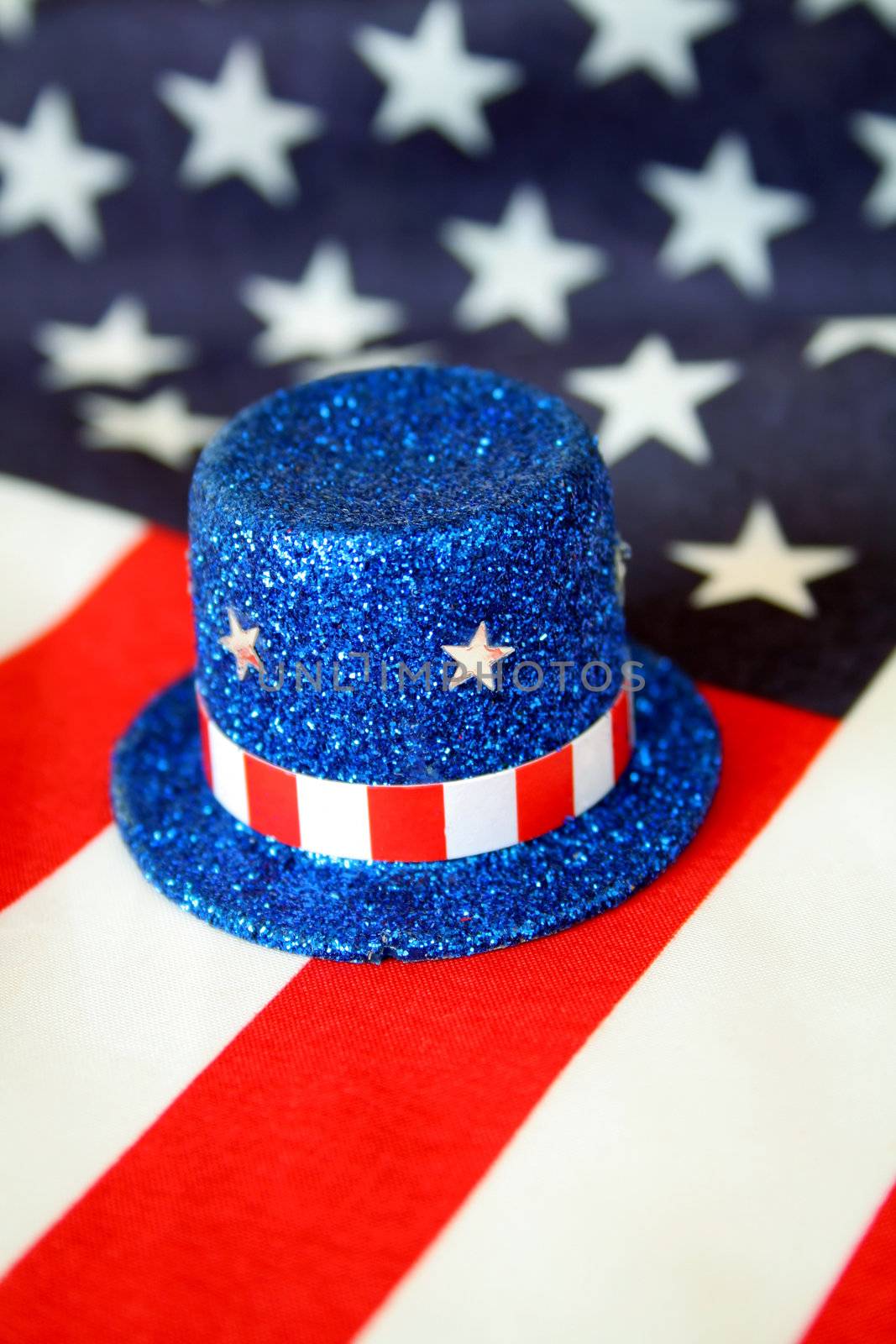 A top hat of blue glitter along with stars and stripes.  American flag is used as the background.