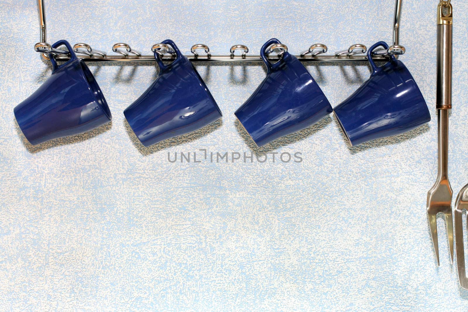 Four dark blue cups on a background of a wall