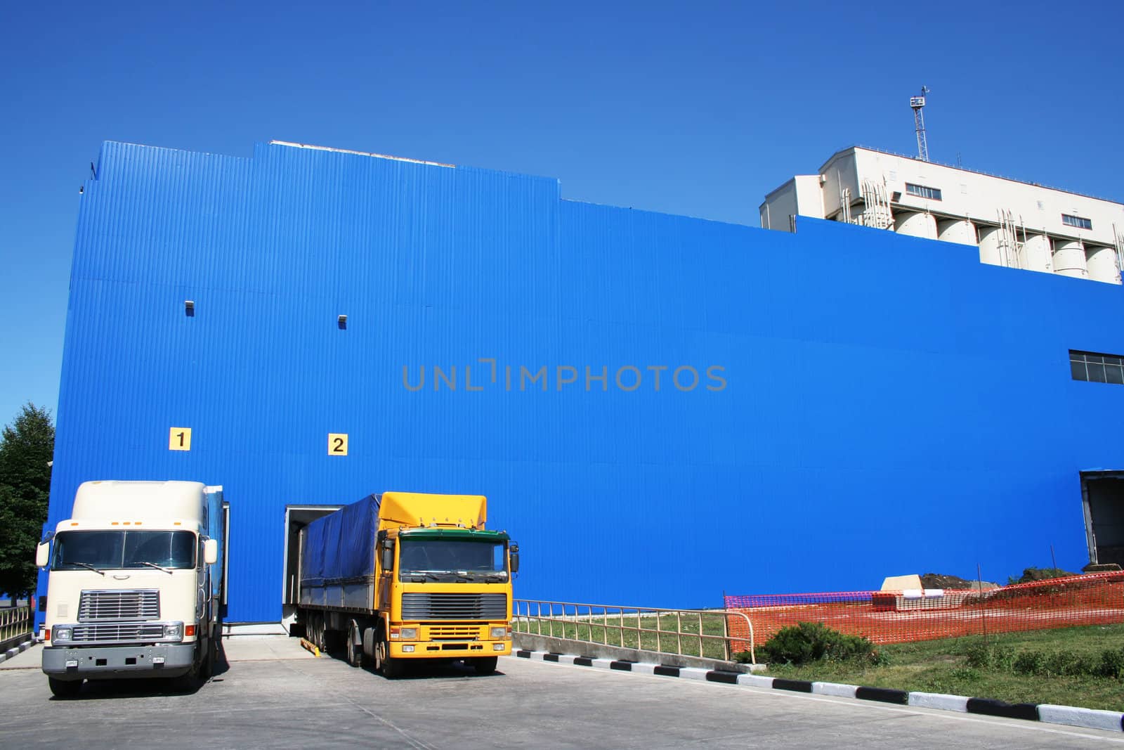 Two lorries on a background of a dark blue warehouse
