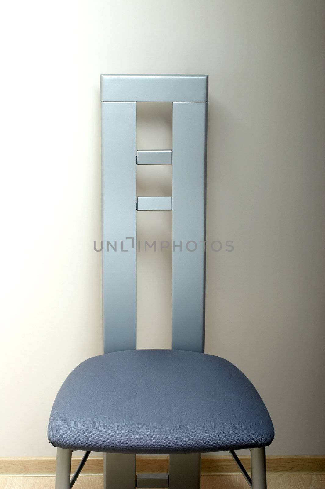 Chair with a high metal back about a wall