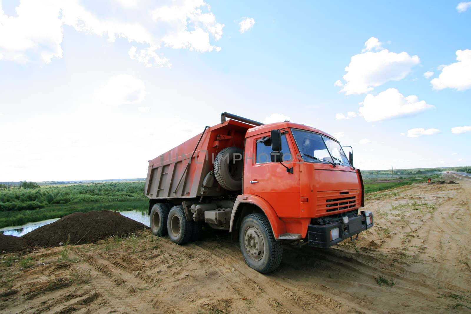 Red dumper on a under construction road