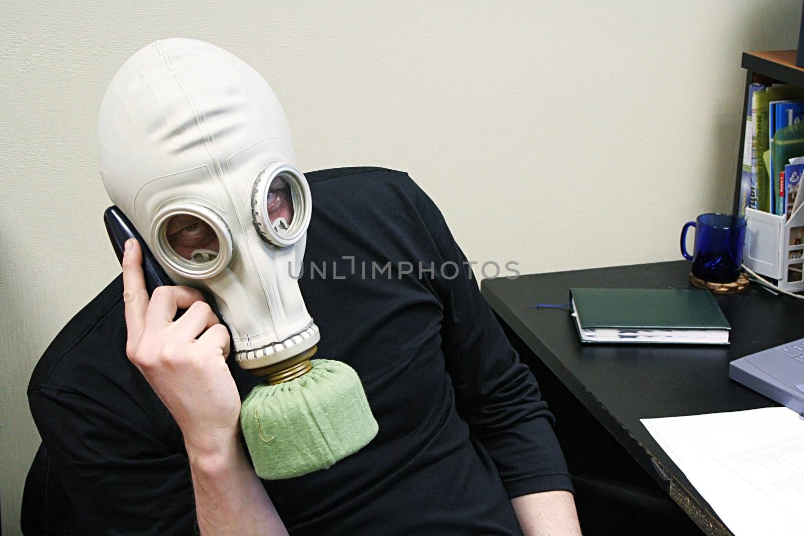 The person in a gas mask speaks by phone