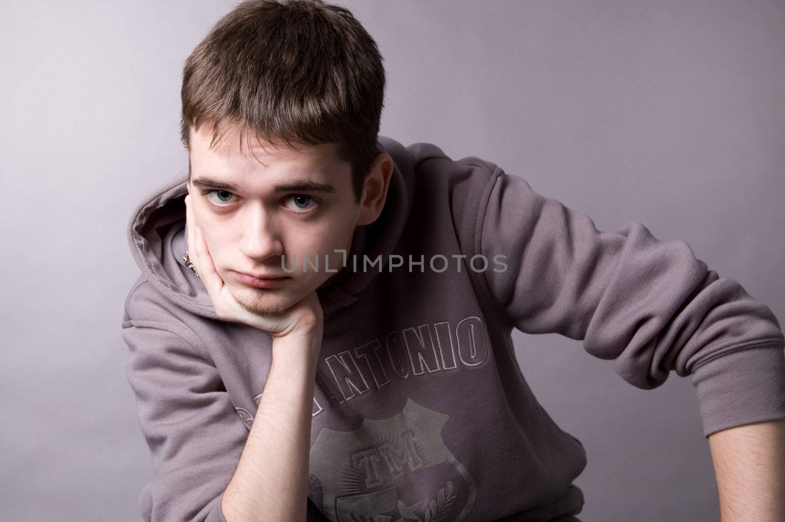 The young guy in studio on a grey background