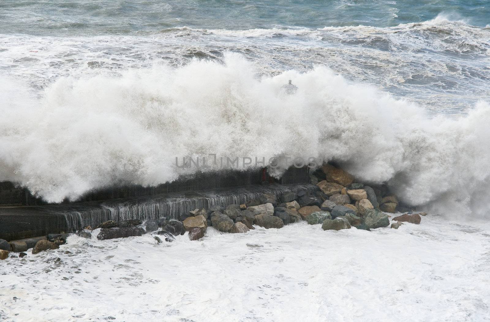 Giant wave breaks on the lighthouse during a storm in Mediterranean sea