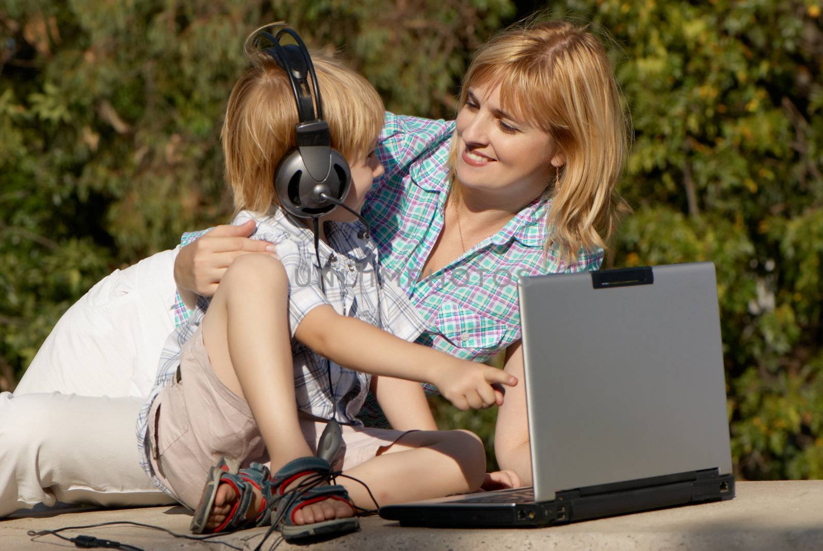 The little boy and mother with the laptop in park